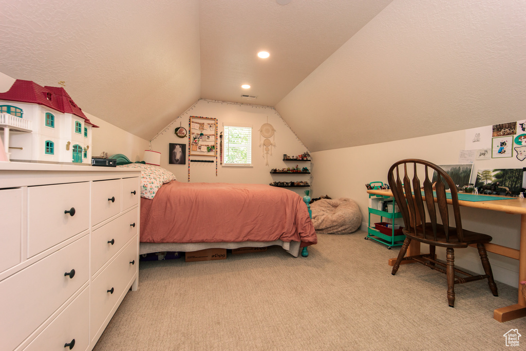 Bedroom featuring light colored carpet and vaulted ceiling