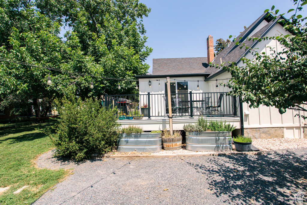 Back of property with a wooden deck and a chimney