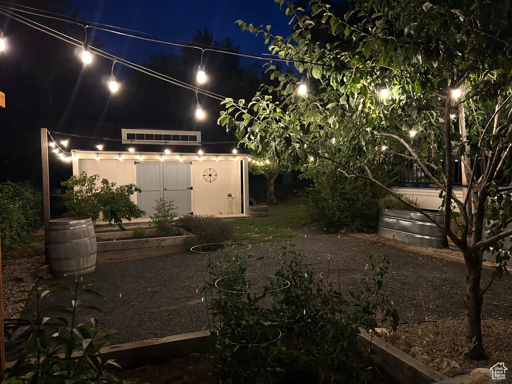 Yard at night featuring a storage shed