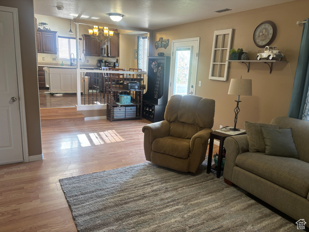 Living area with wood finished floors and a chandelier