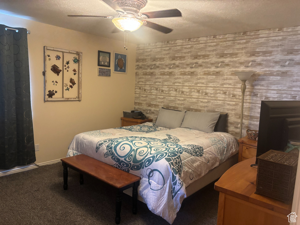 Bedroom featuring a textured ceiling, a ceiling fan, and carpet flooring