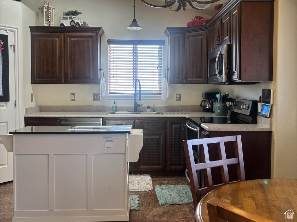 Kitchen featuring dark brown cabinets, electric range oven, a chandelier, stainless steel microwave, and hanging light fixtures