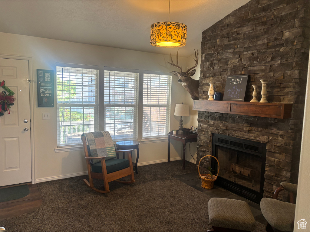 Living room with healthy amount of natural light, a stone fireplace, and vaulted ceiling