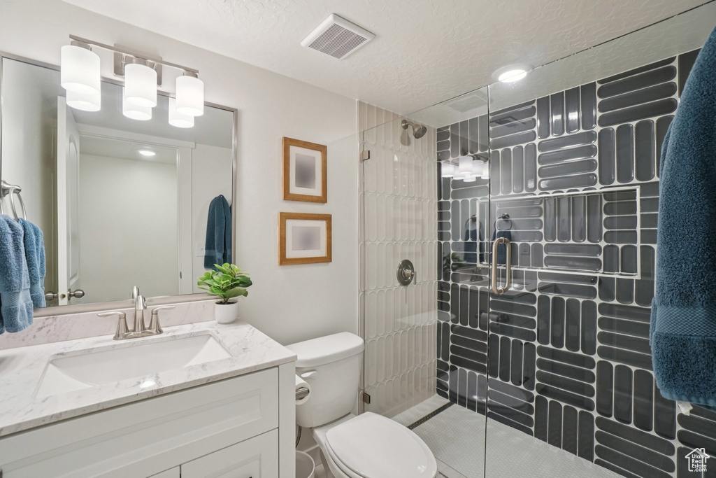 Bathroom with a stall shower, vanity, and a textured ceiling