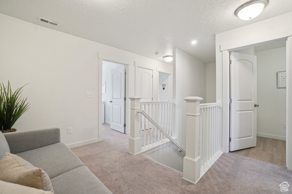 Hall with an upstairs landing and carpet floors