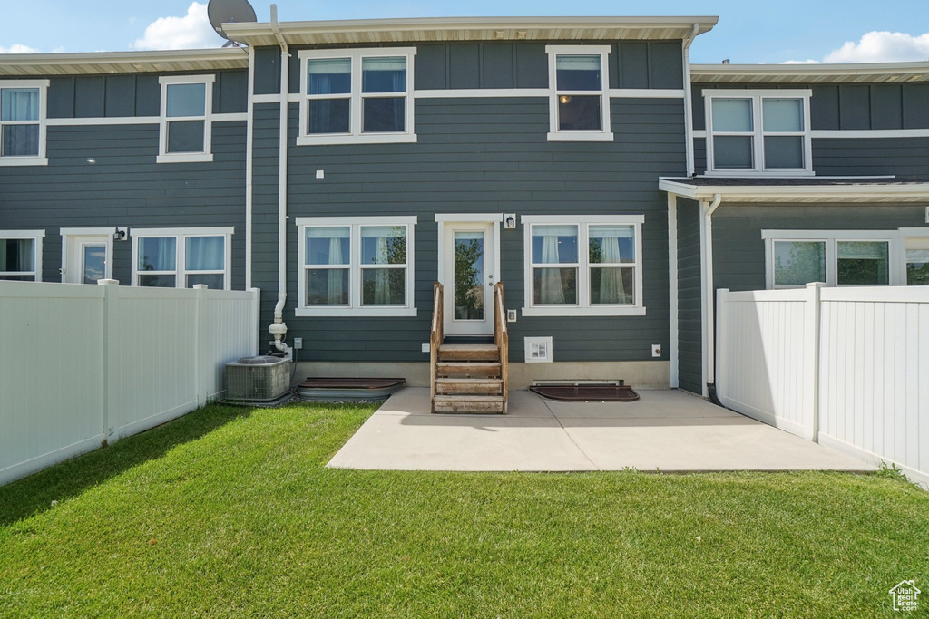 Rear view of house featuring board and batten siding, entry steps, and a patio
