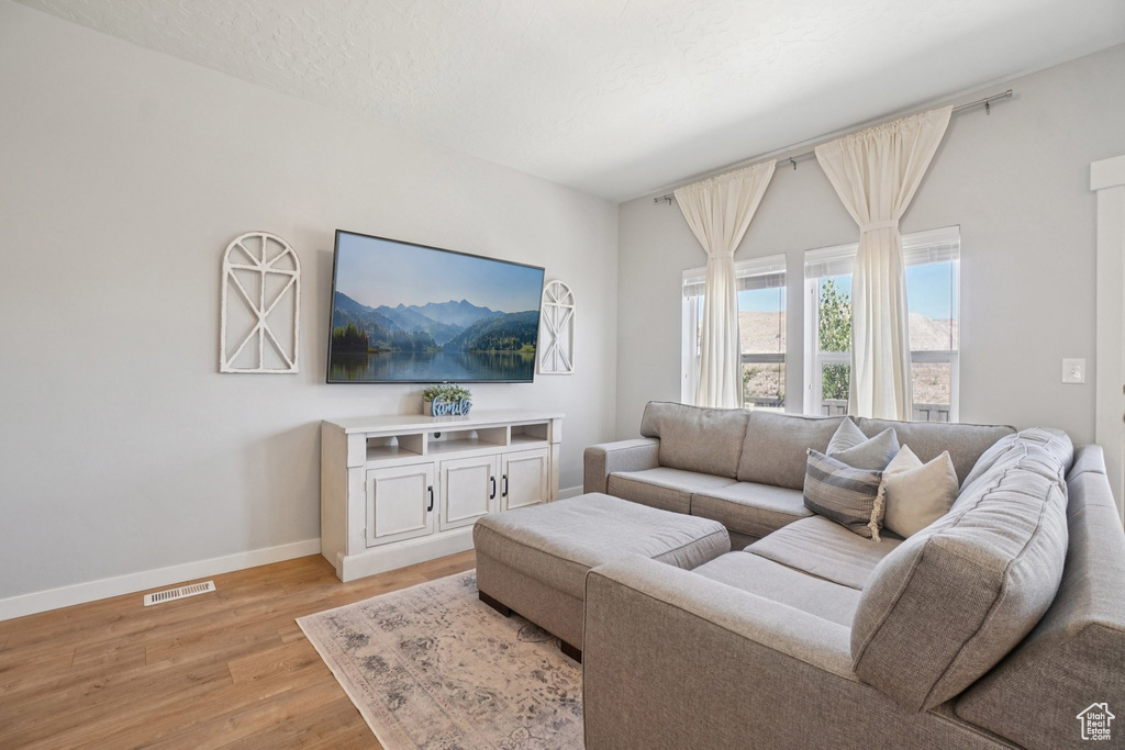 Living area with baseboards and light wood finished floors