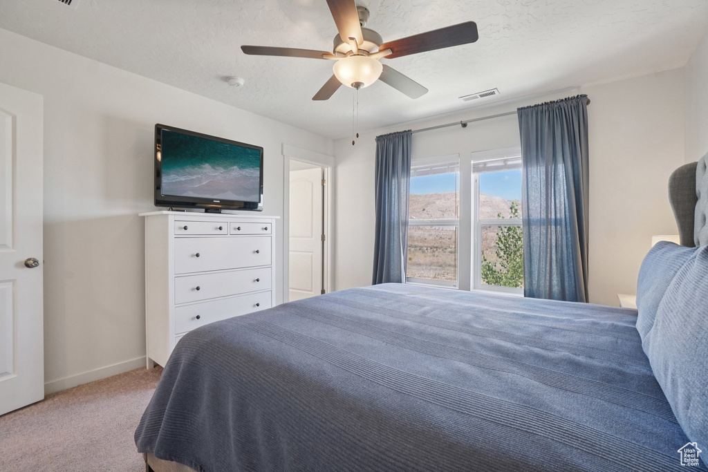 Carpeted bedroom with baseboards and a ceiling fan