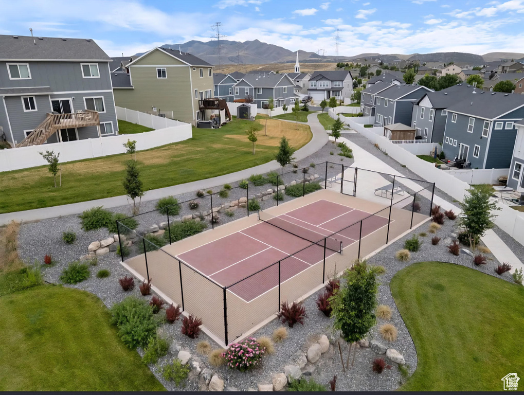 View of tennis court with a residential view and a mountain view