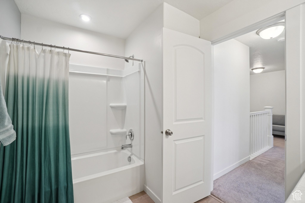 Bathroom featuring shower / bath combination with curtain and baseboards