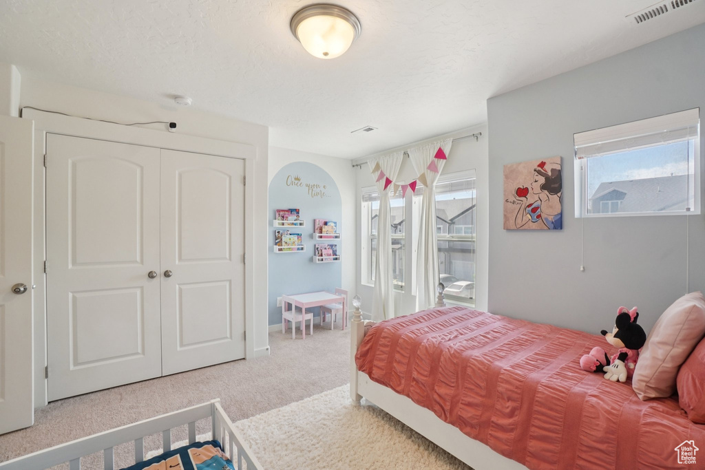 Carpeted bedroom with a closet