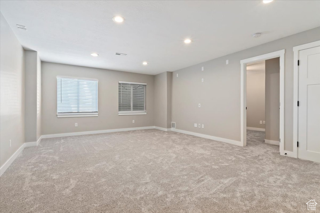 Spare room featuring light colored carpet and recessed lighting