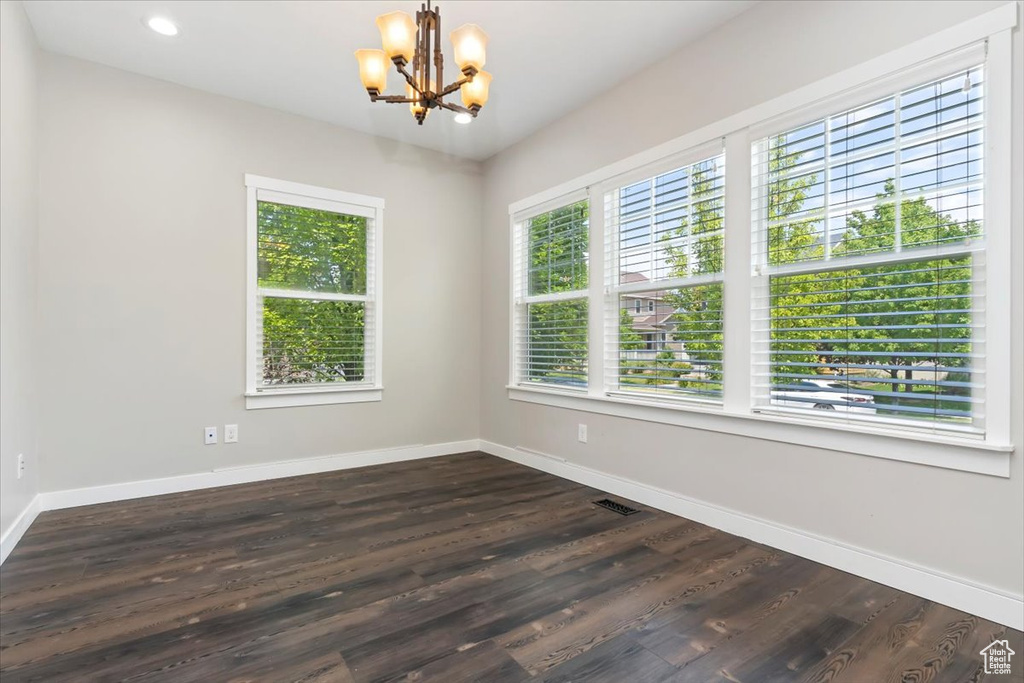 Unfurnished room featuring a chandelier, dark wood-style flooring, and recessed lighting