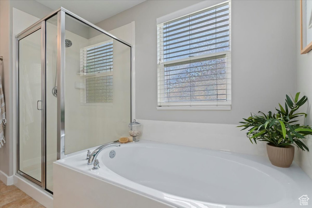 Bathroom featuring a garden tub and a shower stall