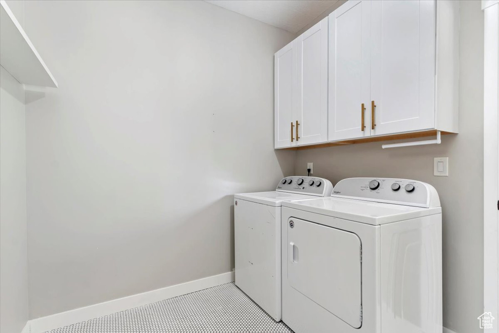 Laundry room featuring cabinet space, washing machine and clothes dryer, and light tile patterned flooring
