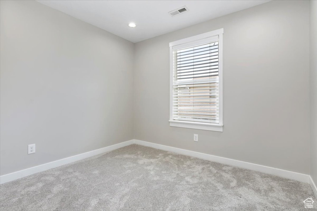Unfurnished room with light colored carpet and recessed lighting