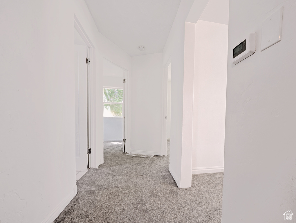 Hall with carpet floors and baseboards