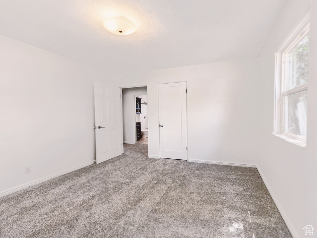 Carpeted empty room with baseboards