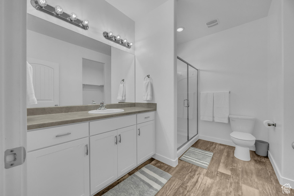 Bathroom featuring vanity, wood finished floors, and a shower stall