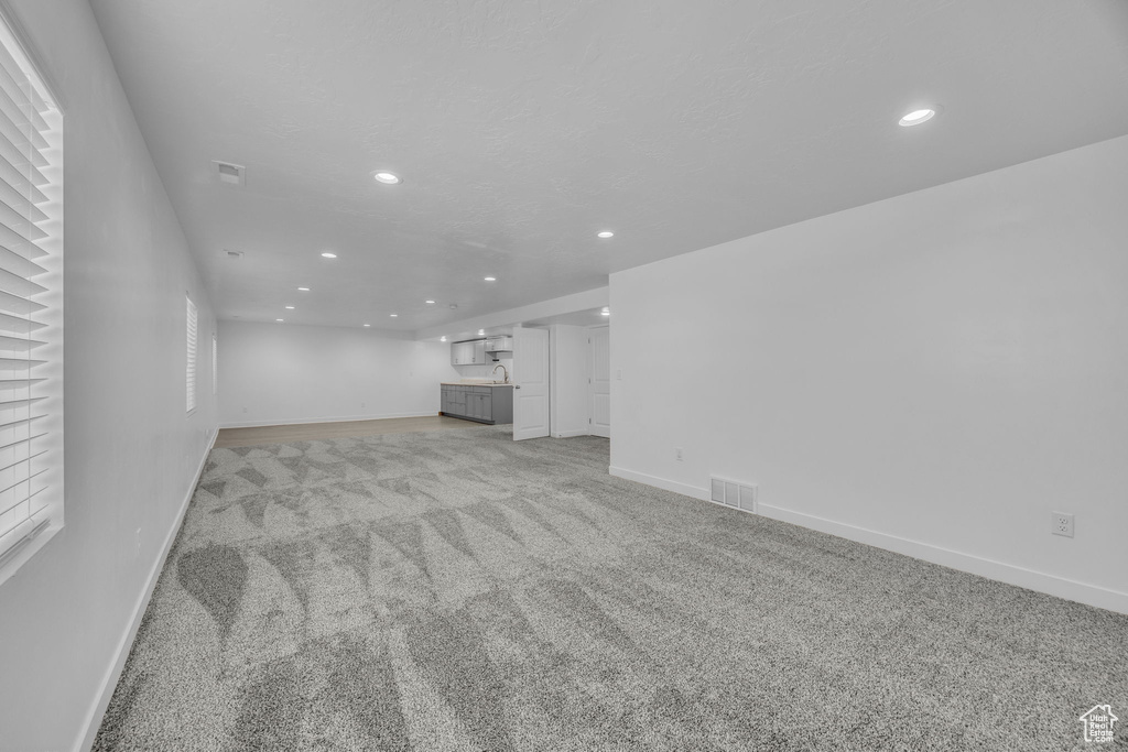 Unfurnished living room featuring recessed lighting and light colored carpet