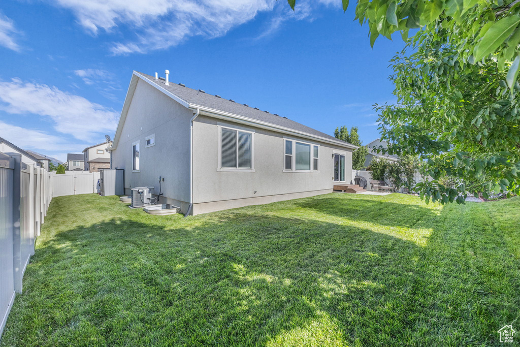 Rear view of house featuring a fenced backyard and stucco siding