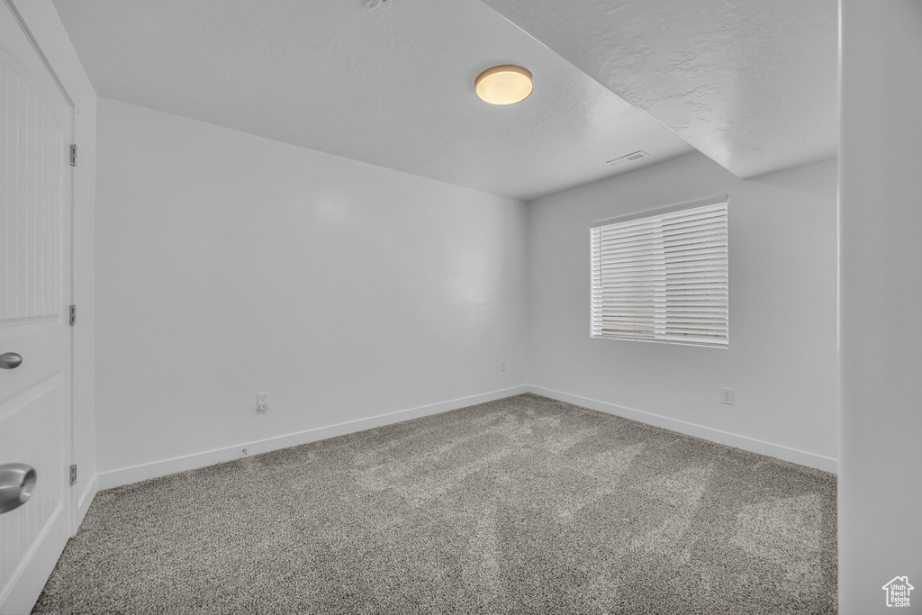 Carpeted spare room with baseboards
