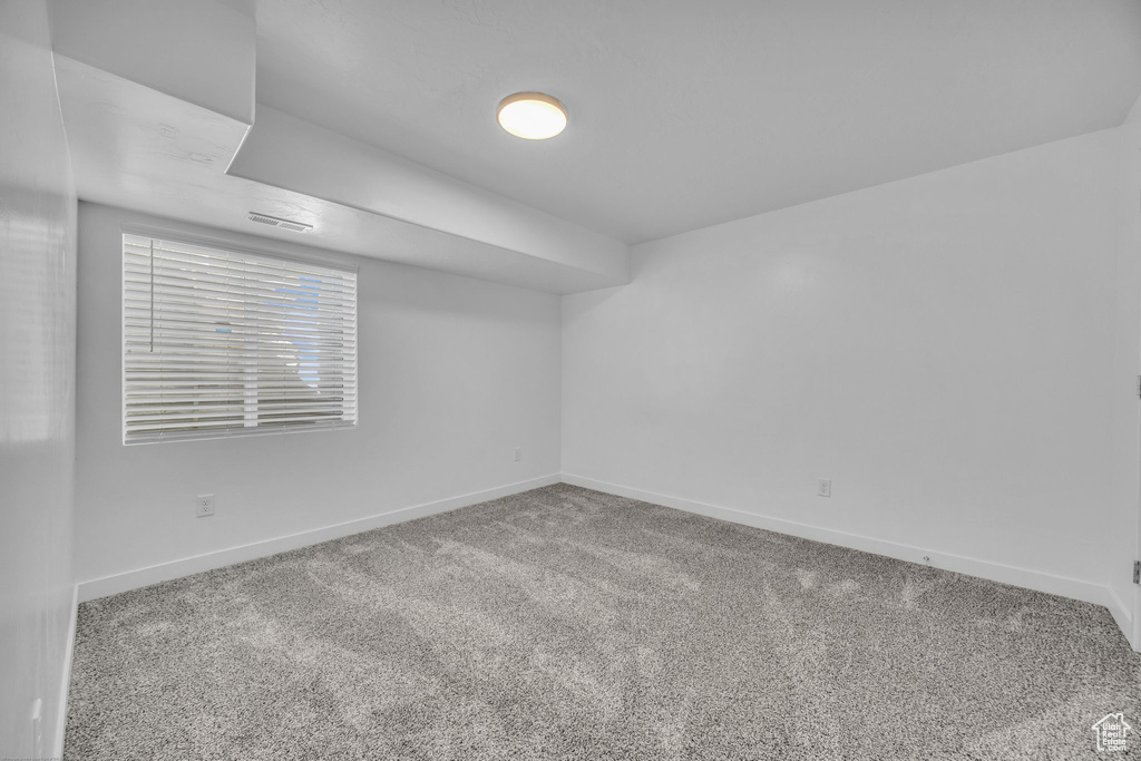 Empty room featuring baseboards and carpet floors