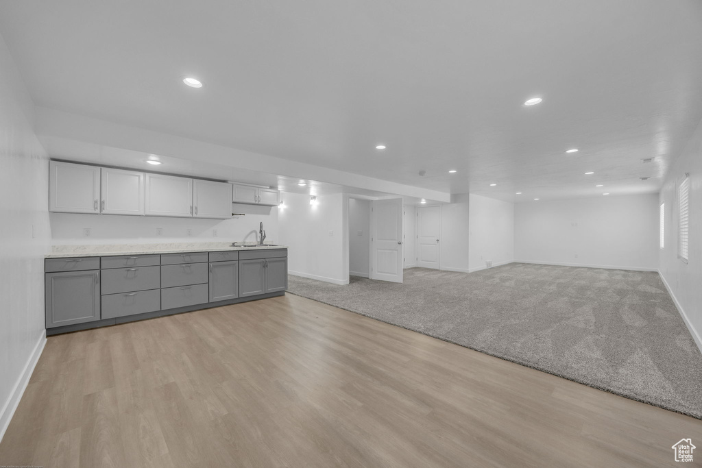 Kitchen with gray cabinets, recessed lighting, light wood-style floors, light countertops, and open floor plan