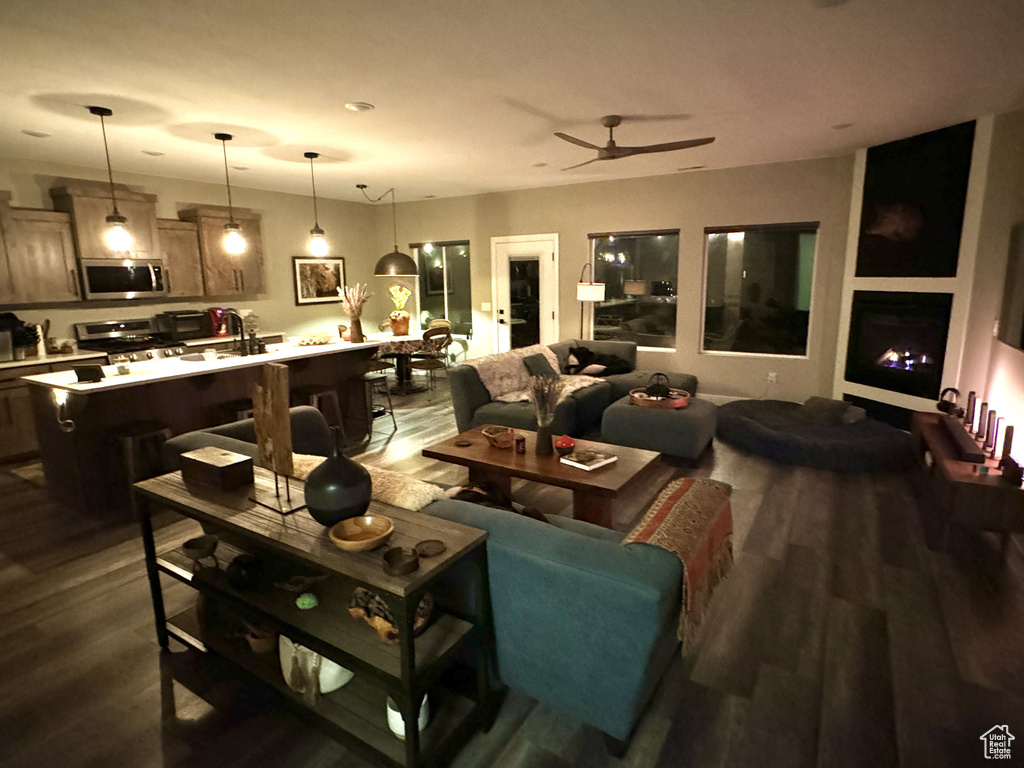 Living room with dark wood-style floors and ceiling fan