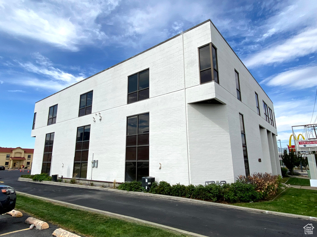 View of building exterior featuring uncovered parking