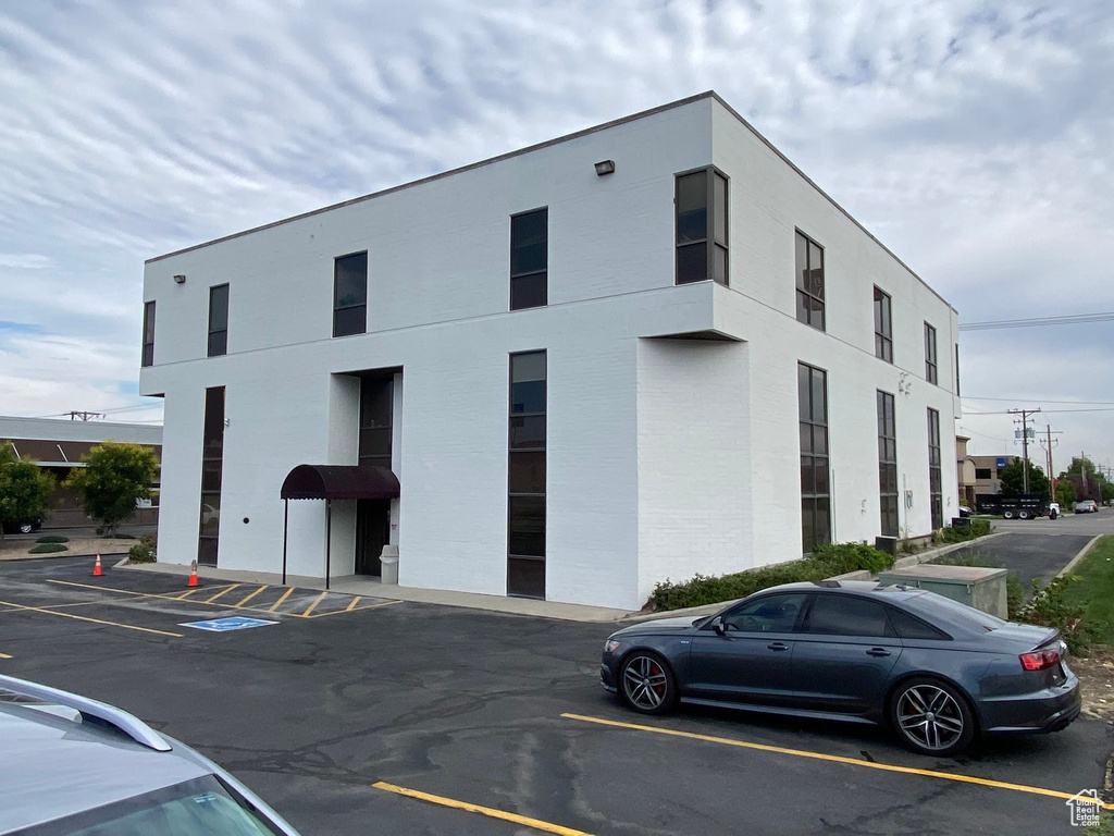 View of building exterior featuring uncovered parking
