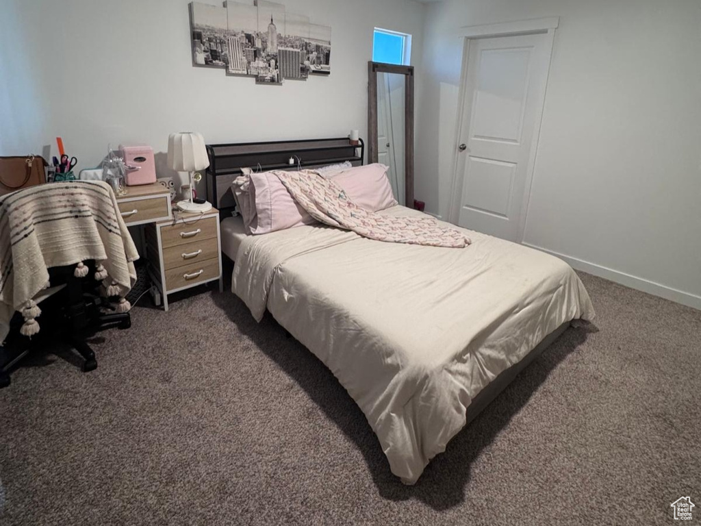 Bedroom with dark colored carpet and baseboards