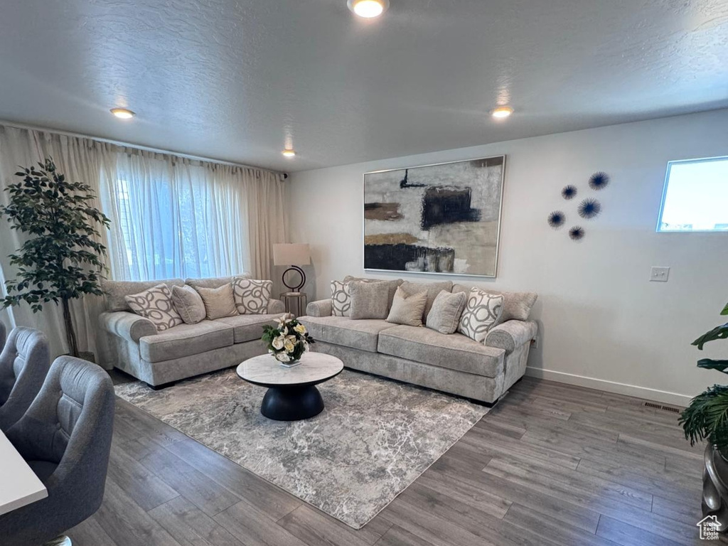 Living room featuring wood finished floors, a textured ceiling, and recessed lighting