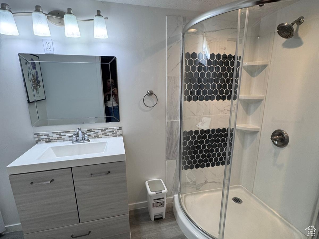 Bathroom with a stall shower, wood finished floors, a textured ceiling, and vanity