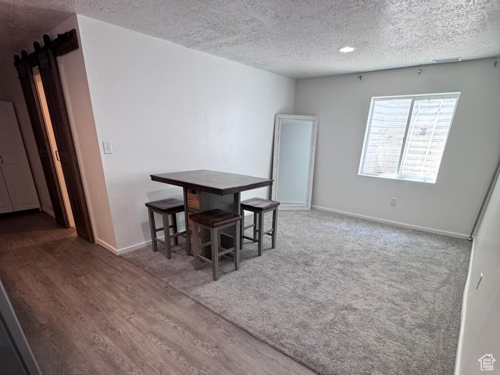 Dining space featuring a textured ceiling, wood finished floors, and recessed lighting