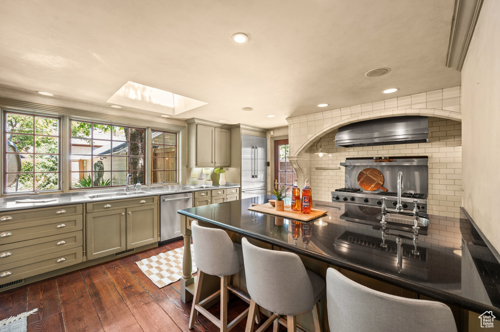 Kitchen with a skylight, tasteful backsplash, gray cabinetry, plenty of natural light, and recessed lighting