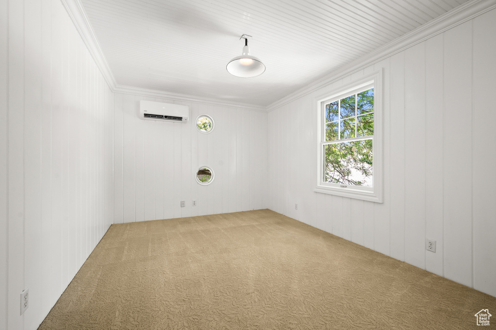 Carpeted empty room with ornamental molding and a wall mounted AC