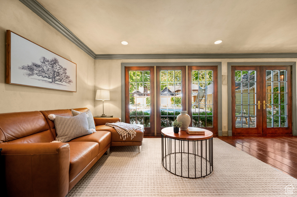 Living area with hardwood / wood-style floors, french doors, ornamental molding, plenty of natural light, and recessed lighting