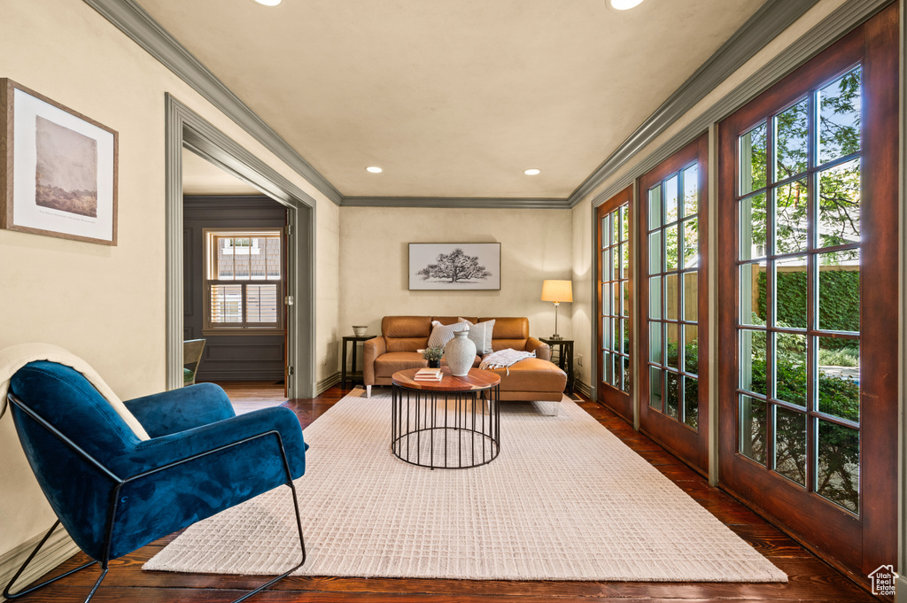 Living room with crown molding, wood finished floors, and recessed lighting