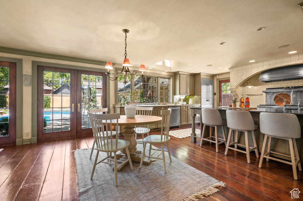 Dining space with french doors, dark wood finished floors, crown molding, and recessed lighting