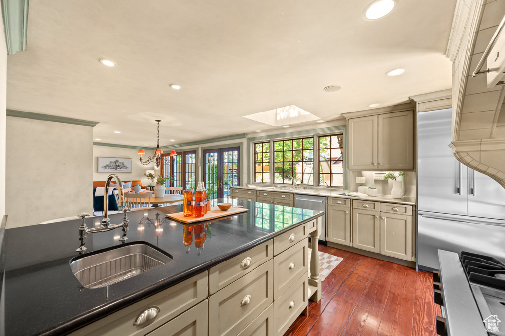 Kitchen with recessed lighting, stainless steel appliances, a skylight, dark wood-style flooring, and hanging light fixtures