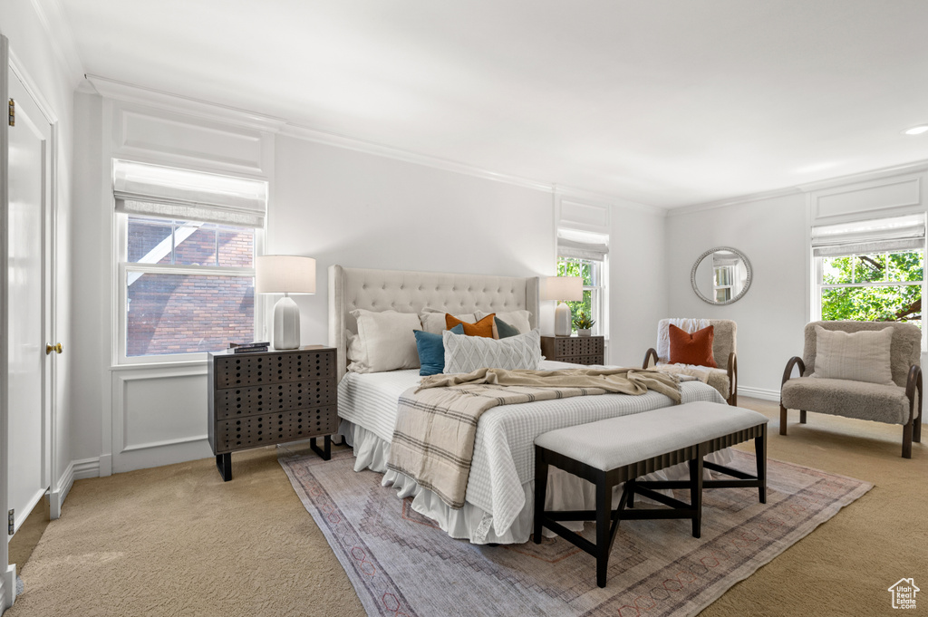 Bedroom with light carpet, multiple windows, and crown molding