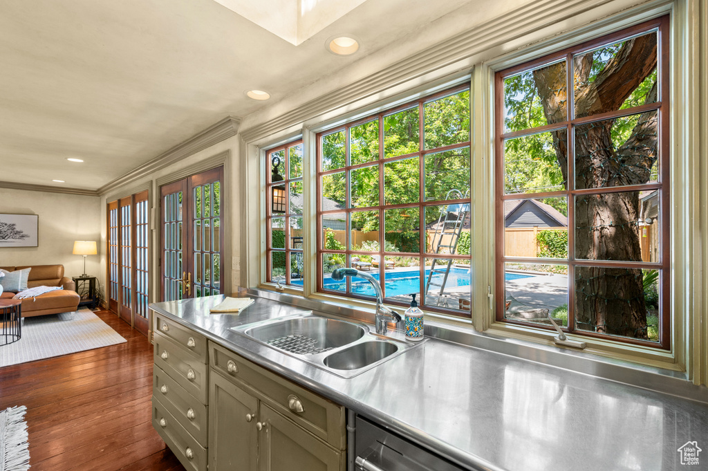 Kitchen with stainless steel countertops, dark wood finished floors, ornamental molding, and recessed lighting