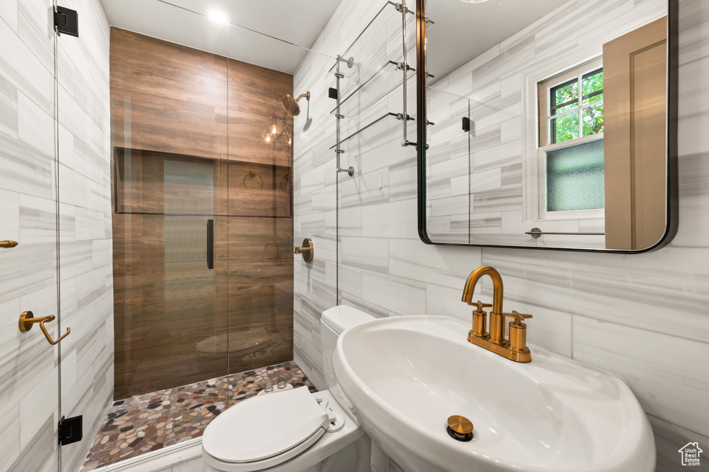 Full bathroom featuring tile walls and a shower stall