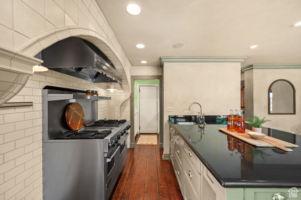 Kitchen featuring island range hood, dark wood-style flooring, dark countertops, recessed lighting, and double oven range