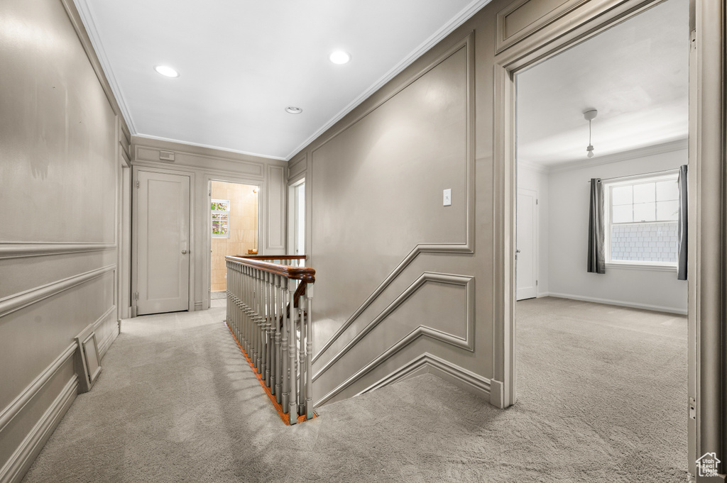Corridor with ornamental molding, carpet flooring, an upstairs landing, healthy amount of natural light, and recessed lighting