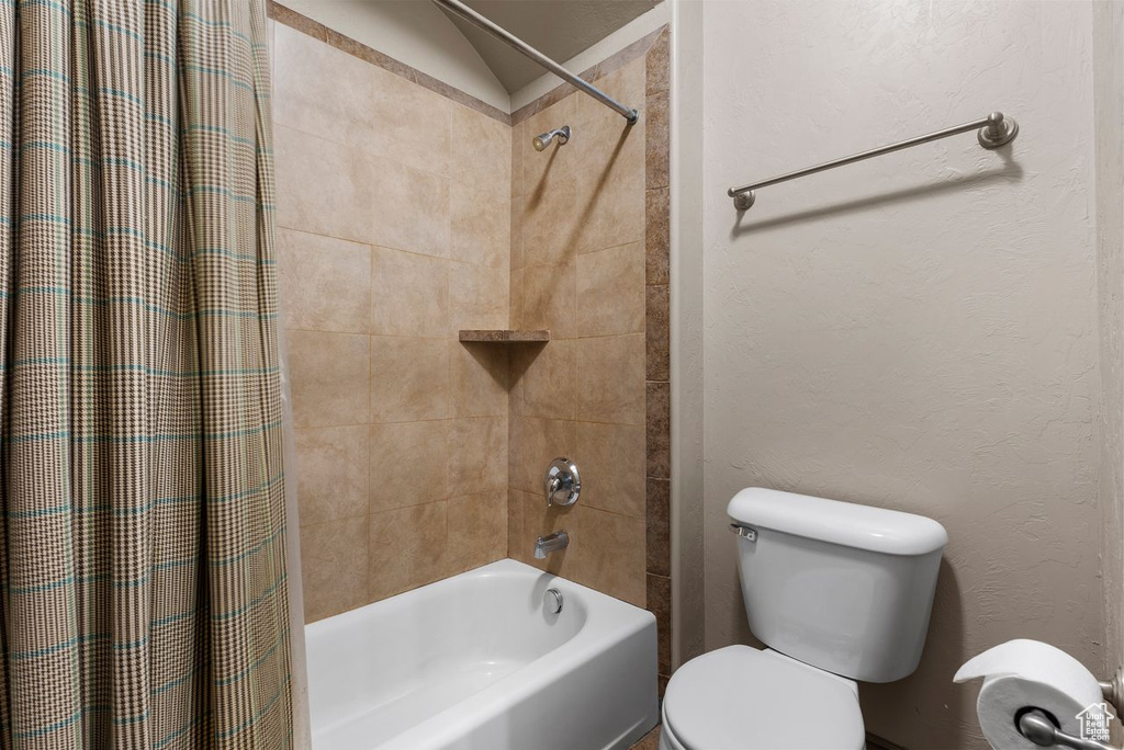 Full bath featuring shower / bath combo with shower curtain and toilet