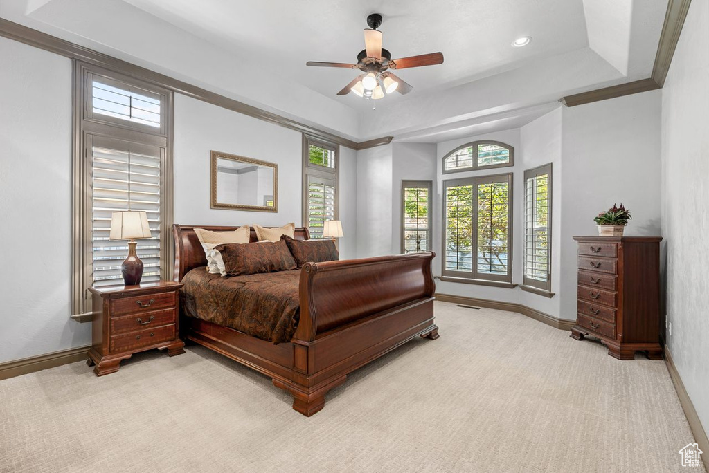 Bedroom with light carpet, a ceiling fan, recessed lighting, and a tray ceiling
