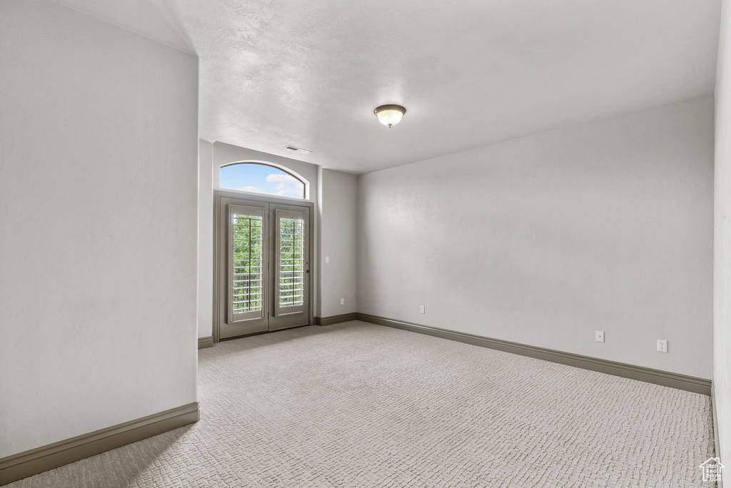 Carpeted spare room featuring baseboards