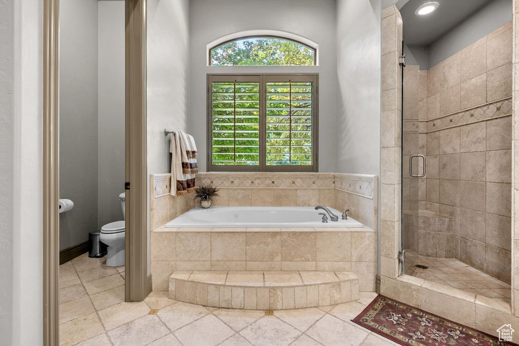 Bathroom featuring a bath, a shower stall, and healthy amount of natural light